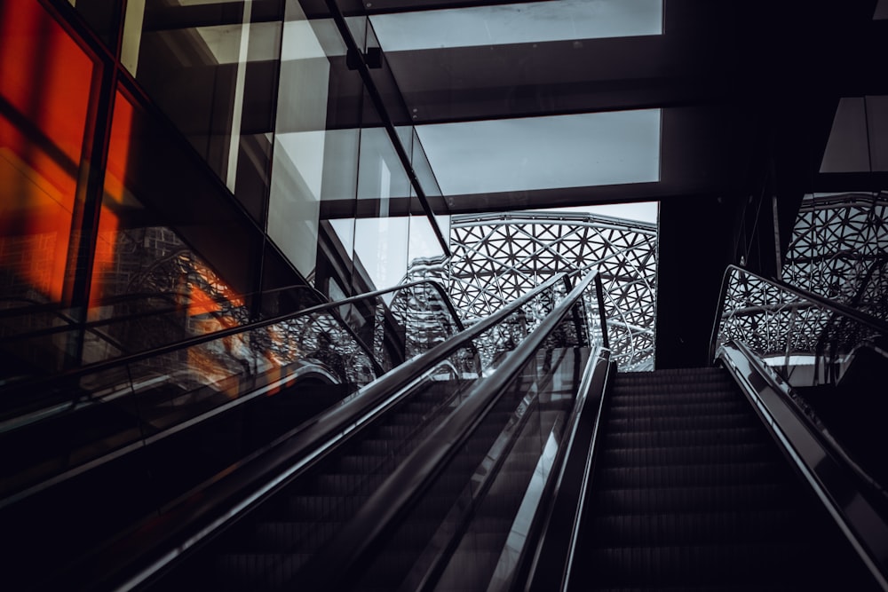 an escalator in a building with a bridge in the background