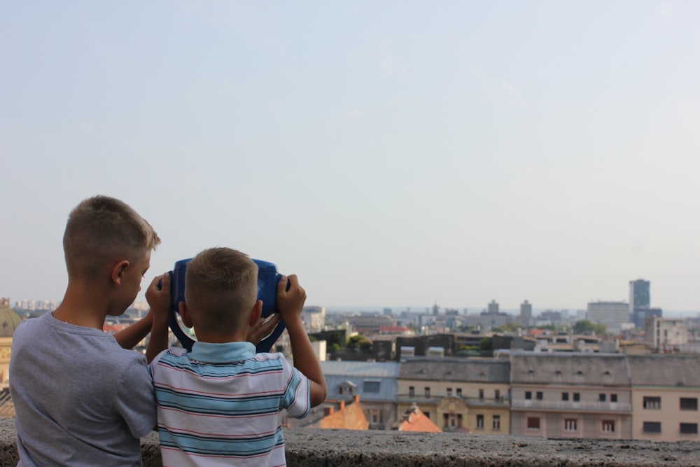 two young boys looking out over a city