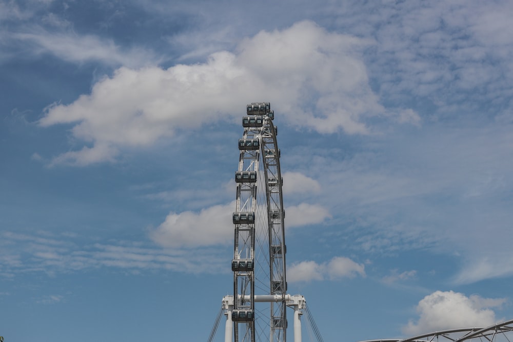 a ferris wheel in front of a cloudy blue sky