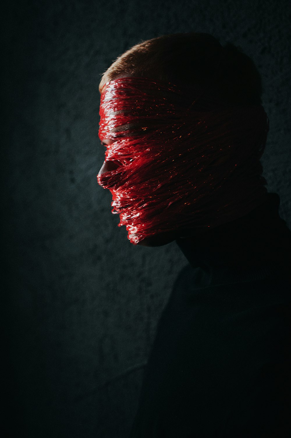 a person with a red hair covering their face