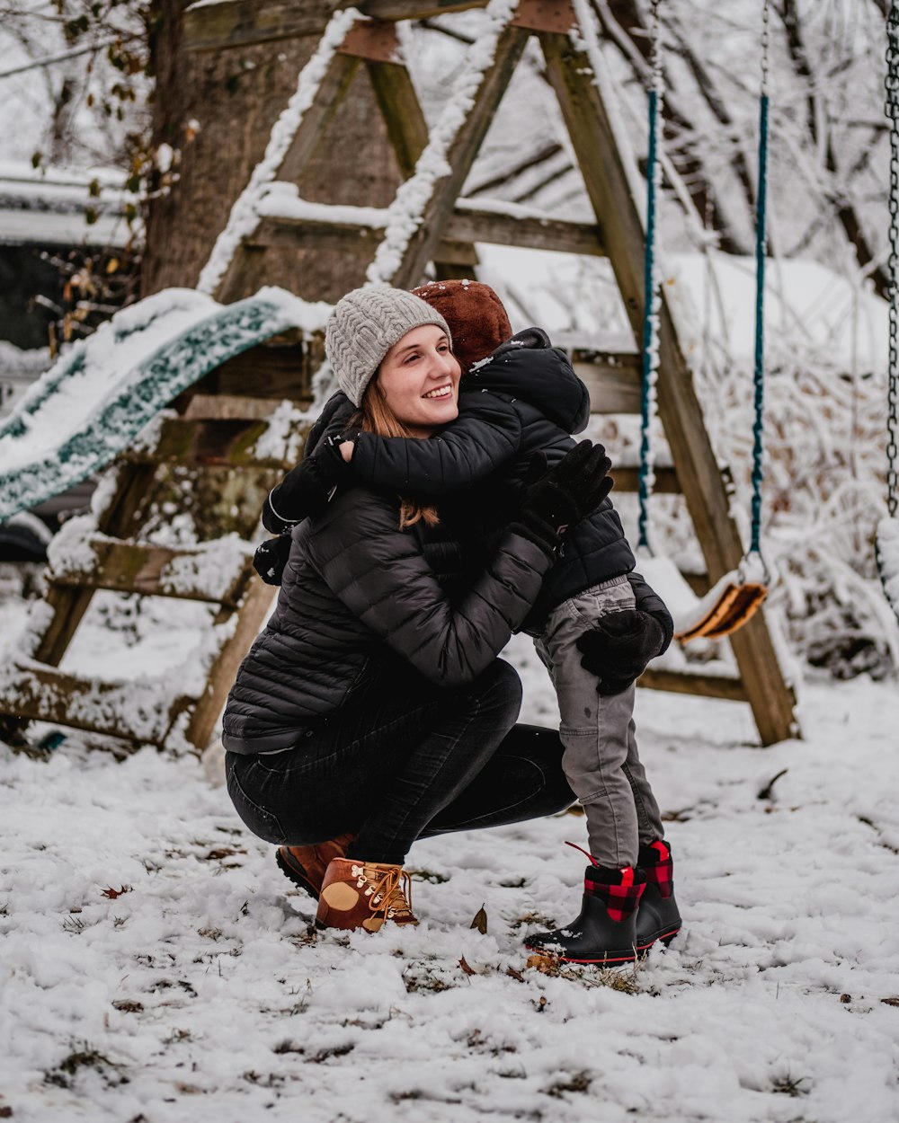 a woman holding a child in the snow