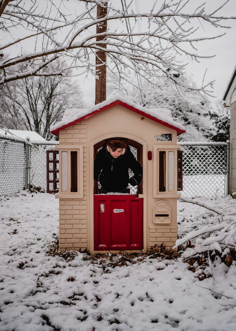 a person standing inside of a small red and beige house