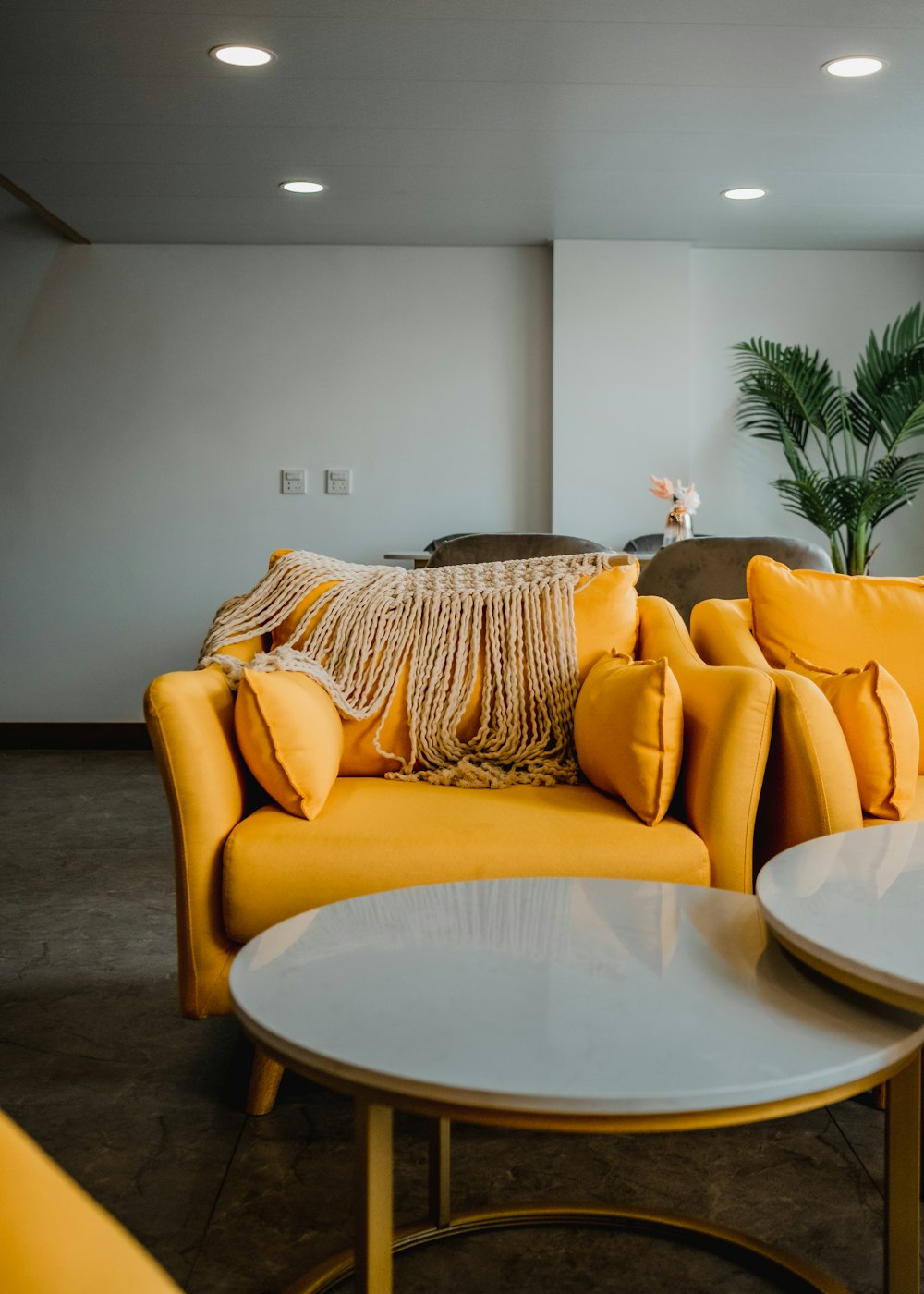 una sala de estar llena de sofás y mesas amarillas