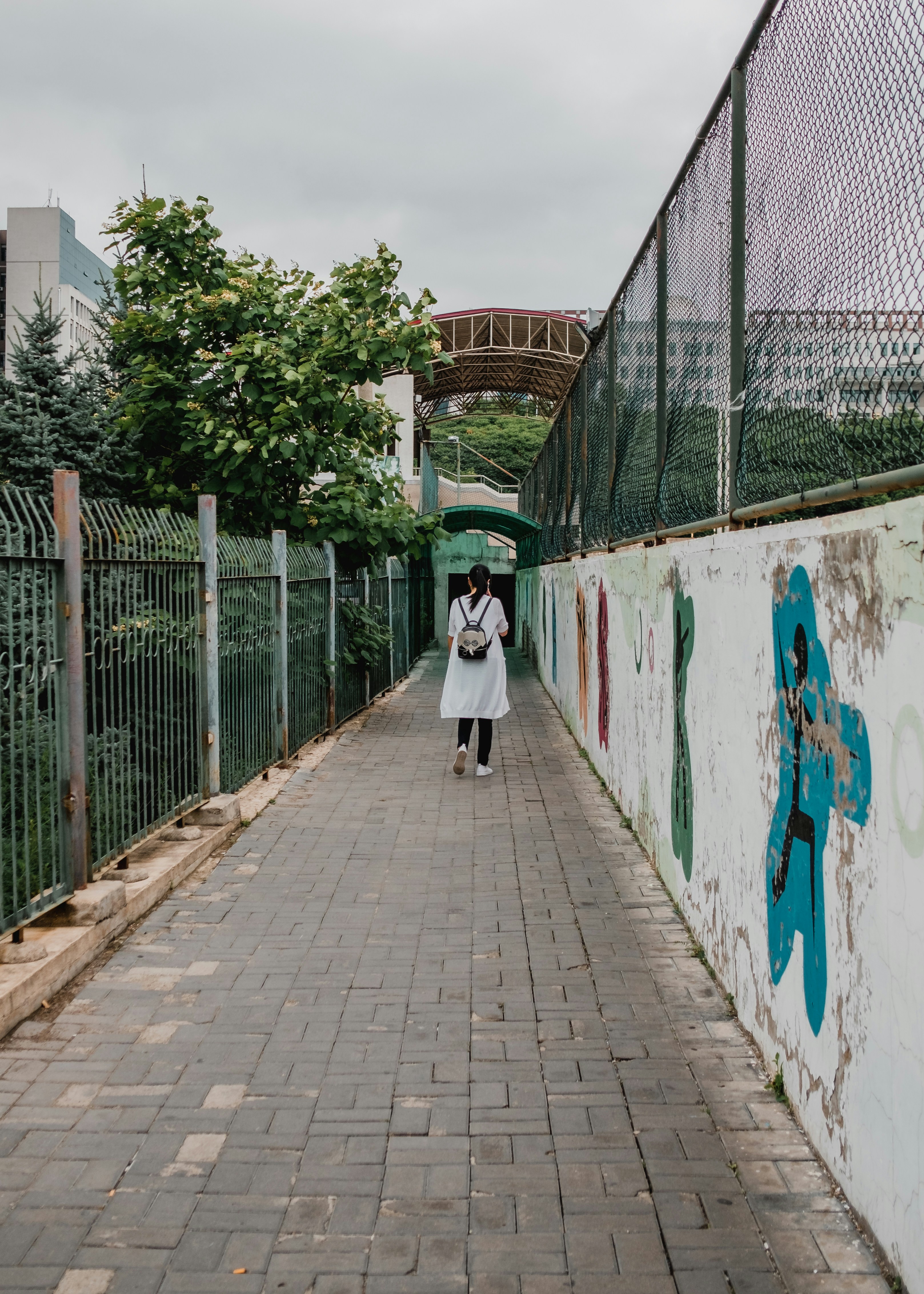 a couple of people walking down a sidewalk