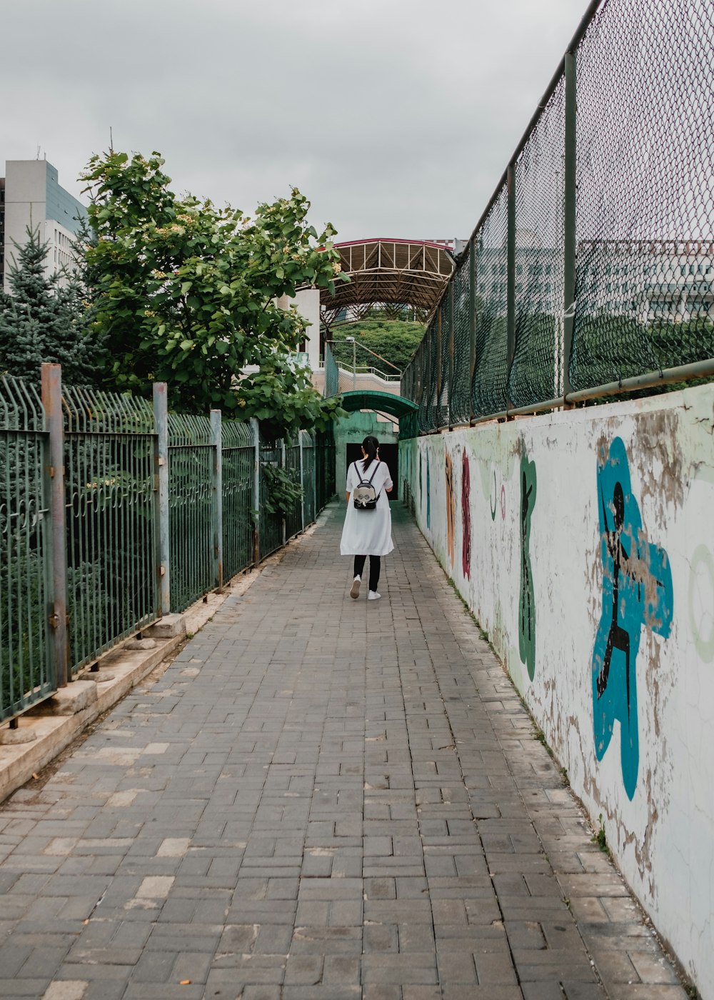 a couple of people walking down a sidewalk