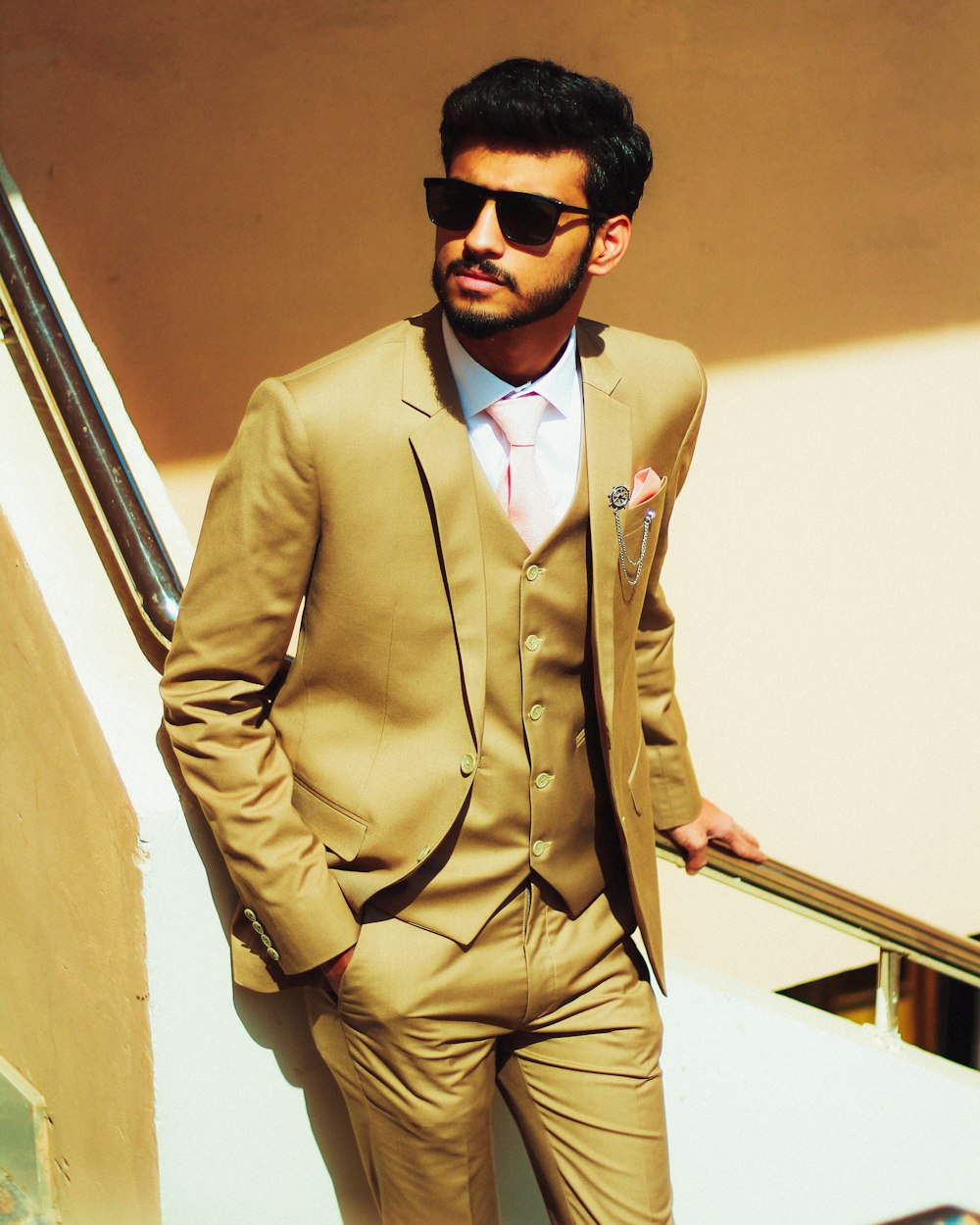 a man wearing a tan suit and sunglasses
