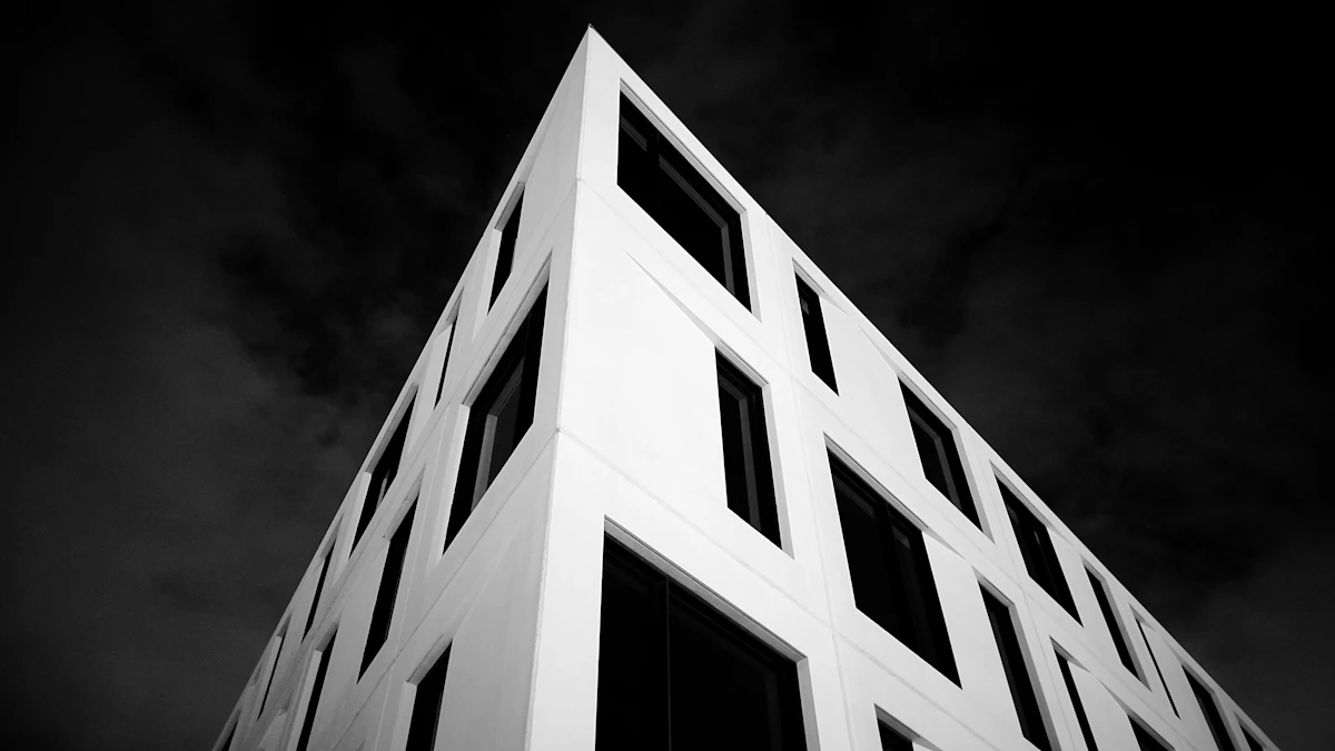 A pale stone office building corner against a dark sky, in black and white
