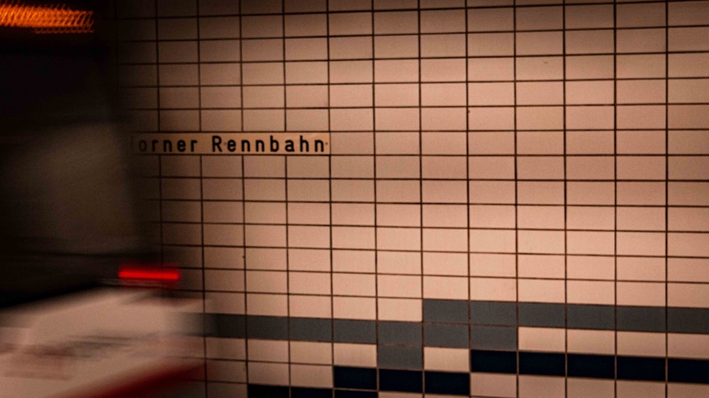 a bathroom with a tiled wall and a red light