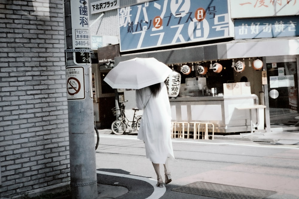 a woman walking down a street holding an umbrella