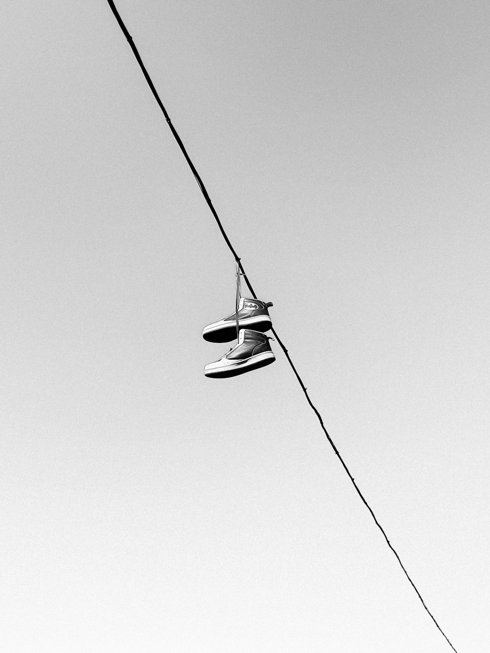 a pair of shoes hanging from a power line