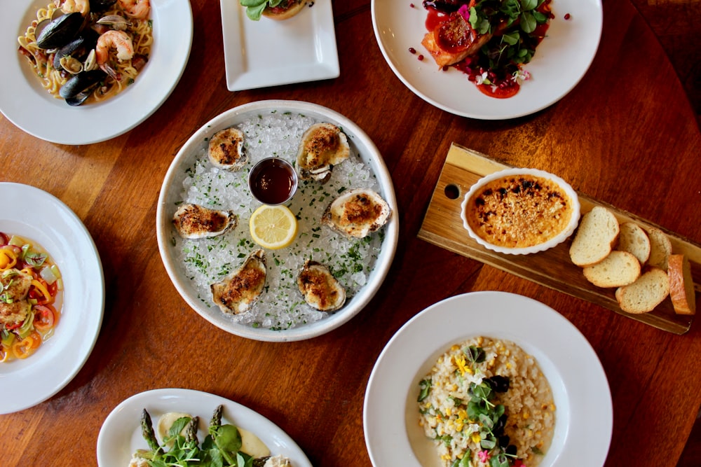 a wooden table topped with plates of food