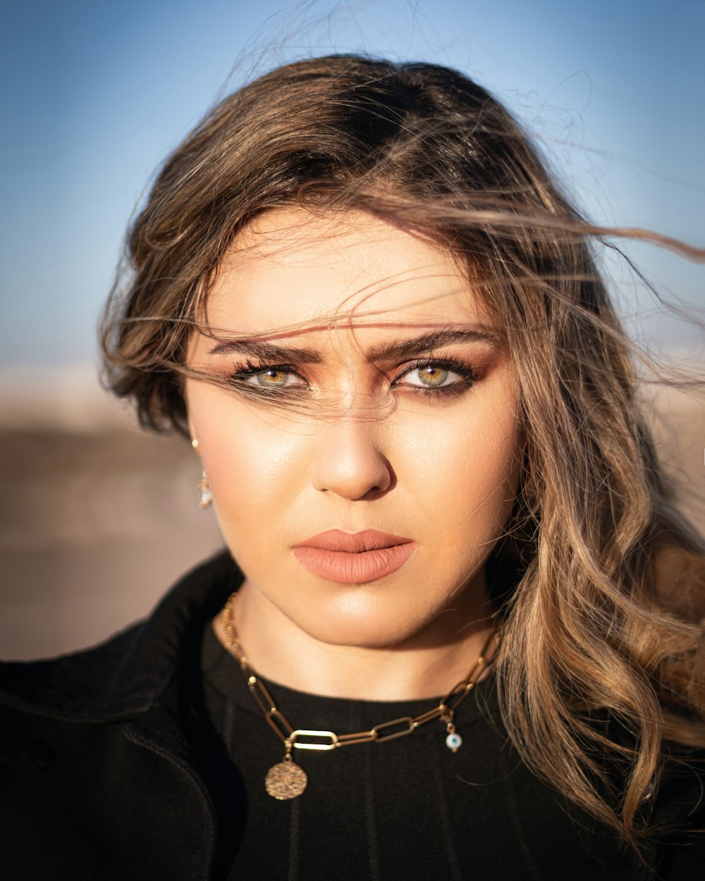 a woman with long hair wearing a necklace