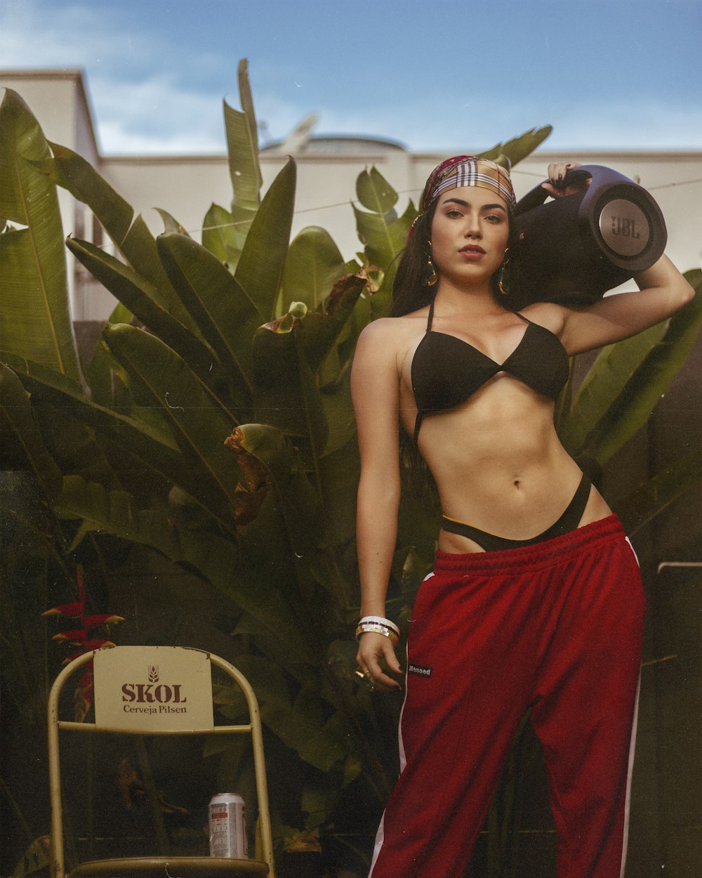 a woman in a bikini top and red pants