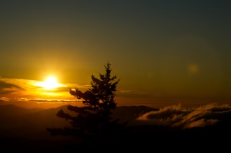 the sun is setting over a mountain range