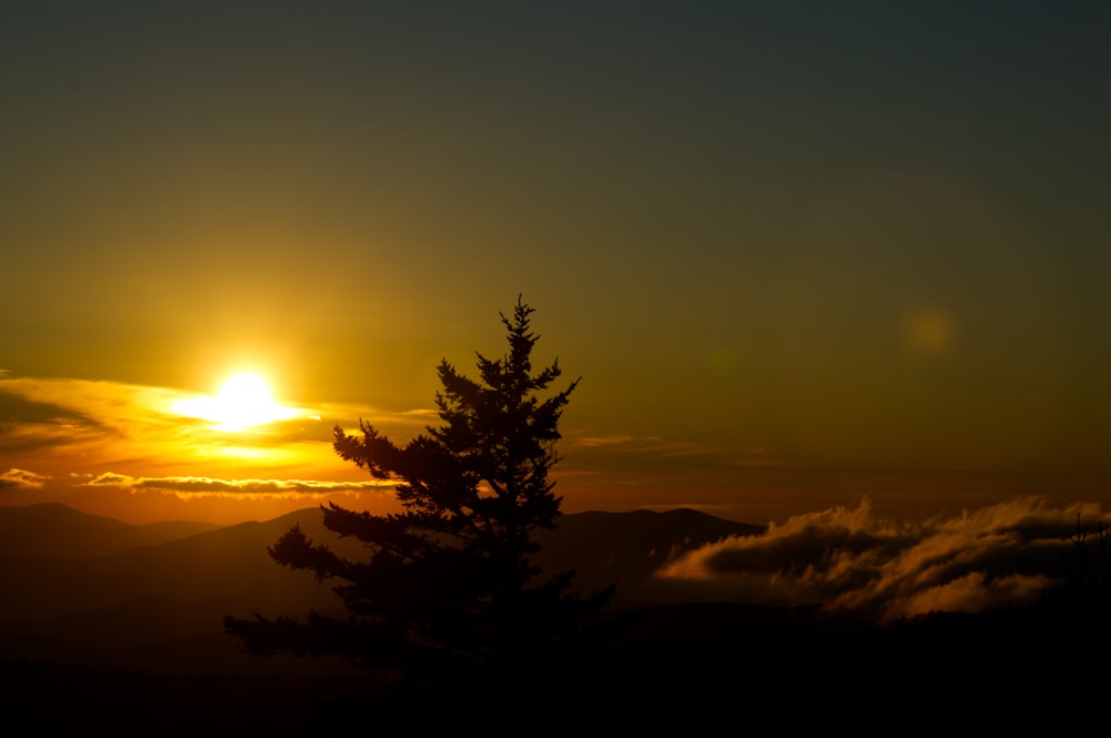 the sun is setting over a mountain range