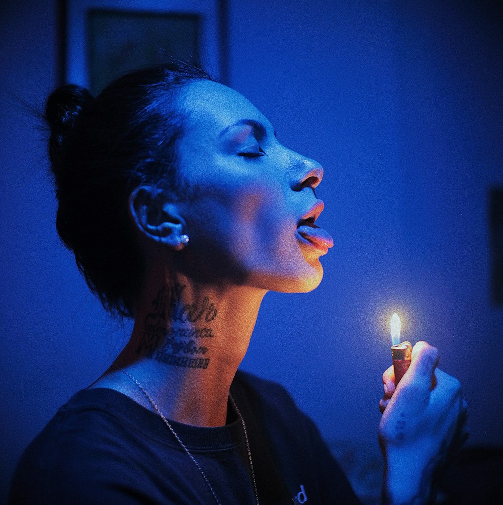 a woman holding a lit cigarette in her hand