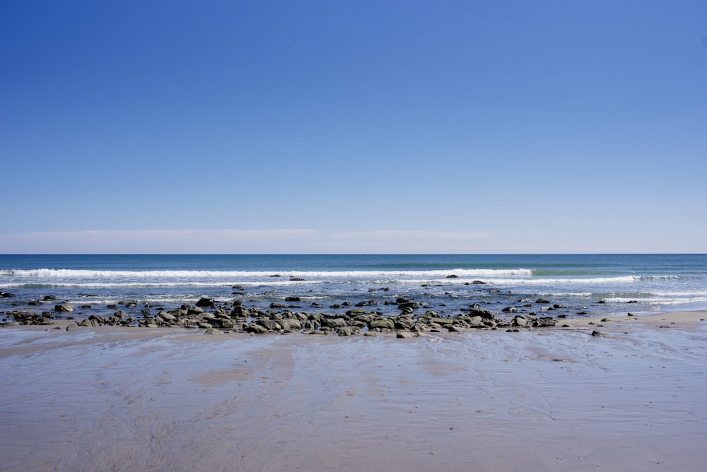 a sandy beach with a wave coming in to shore