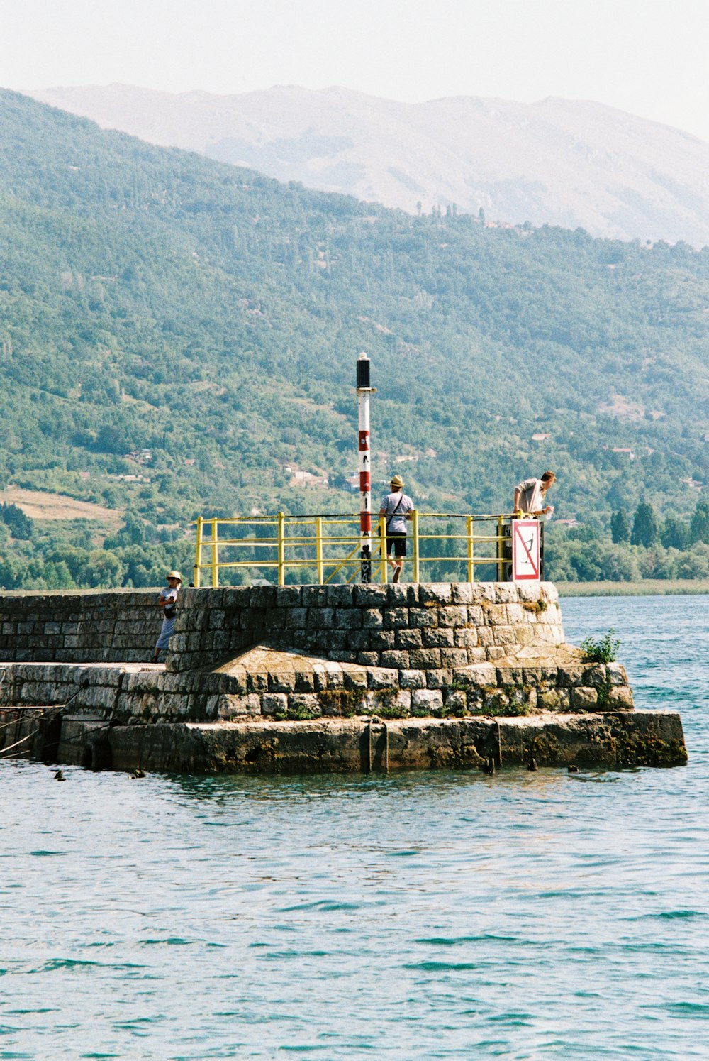 a group of people standing on top of a pier