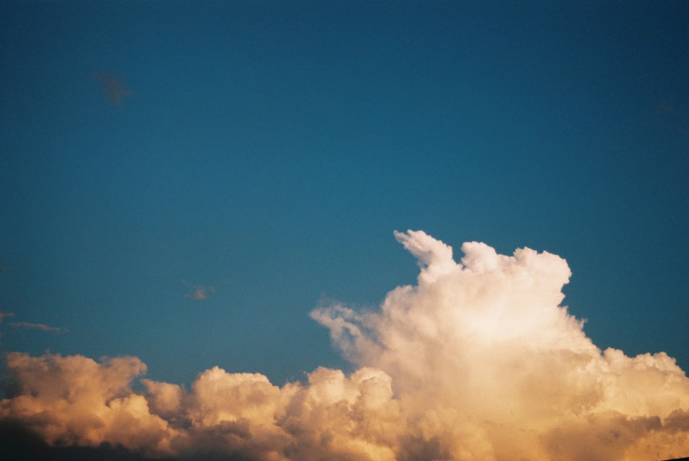 a plane flying through a cloud filled sky