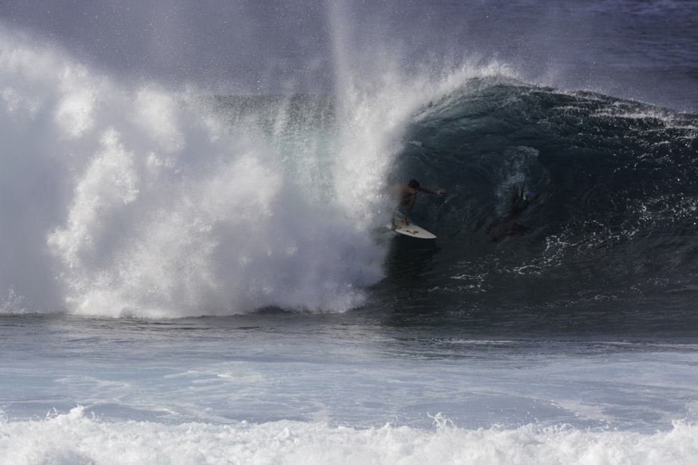 a man riding a wave on top of a surfboard