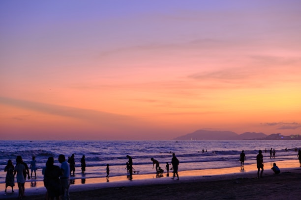 Guests enjoying a peaceful evening on the beach near Hotel Sonar Bangla with the Jagannath Puri temple silhouette in the background.
