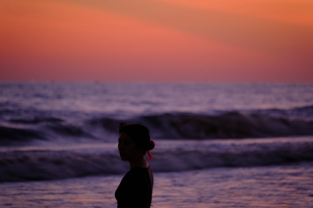 a person standing on a beach near the ocean