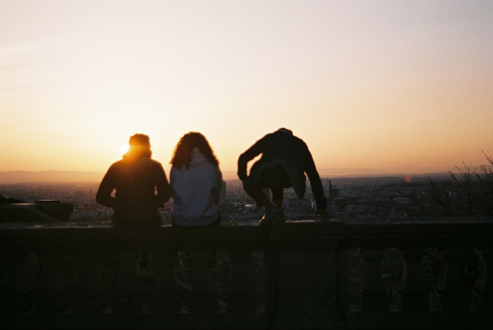 a couple of people sitting on top of a wooden bench