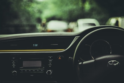 A driver checking the time on a watch, standing next to a car ready for departure.