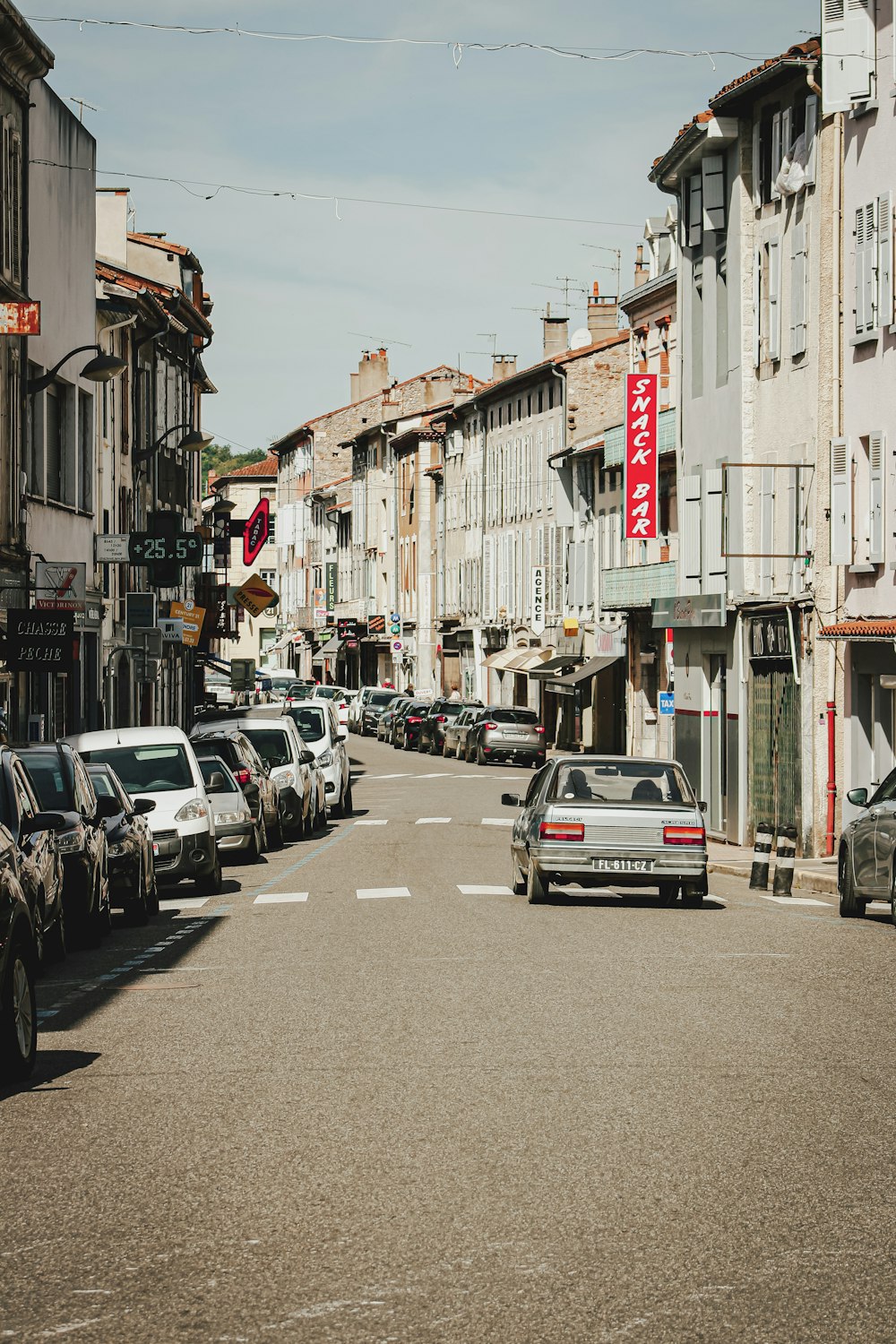 Eine Straße voller geparkter Autos neben hohen Gebäuden