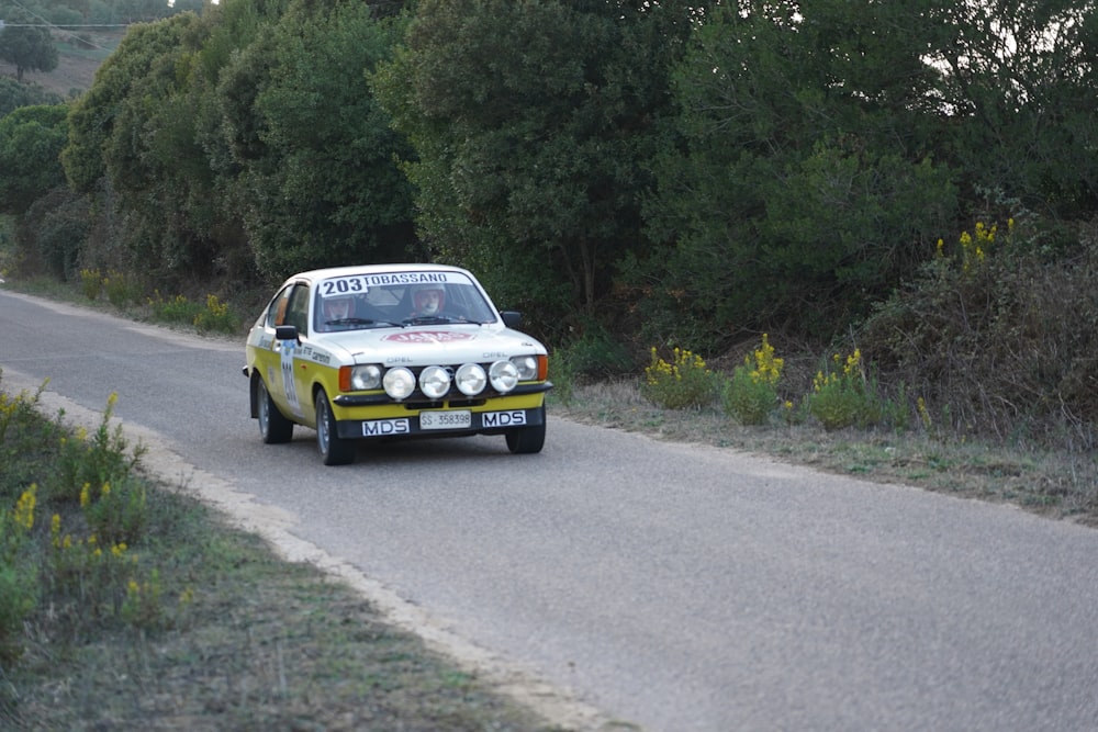 a rally car driving down a country road