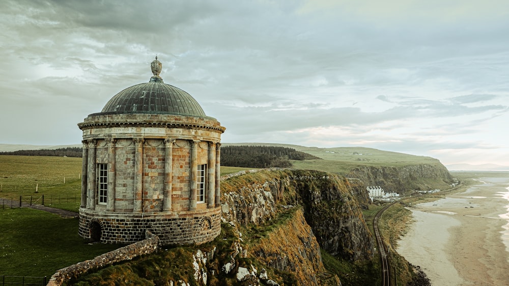 a tower on the side of a cliff next to a body of water