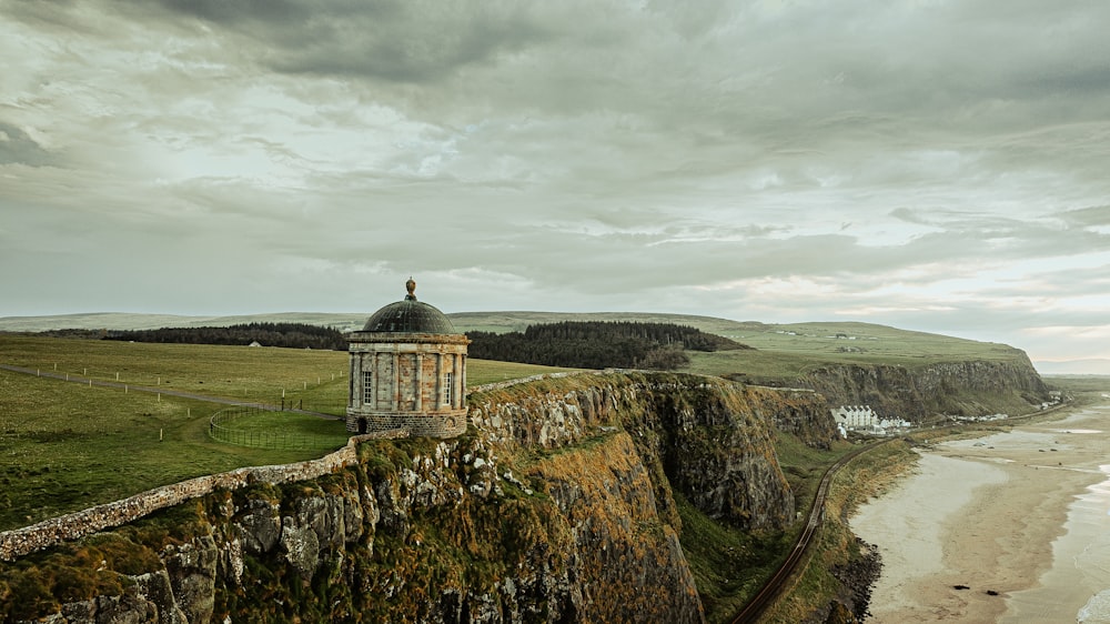 a tower on the side of a cliff next to the ocean