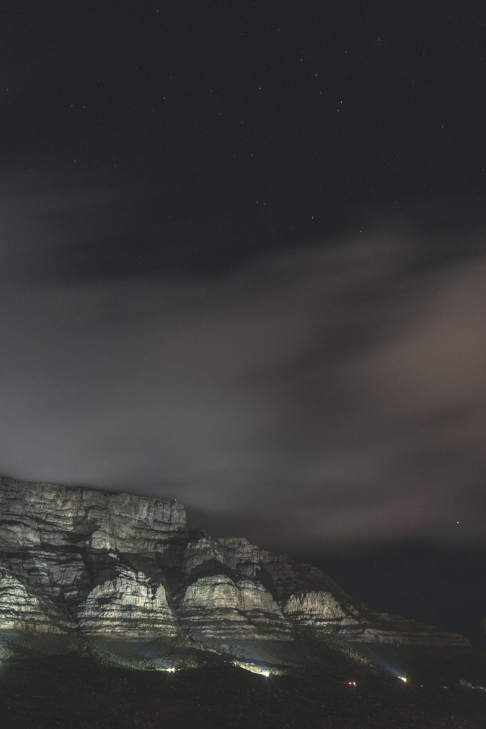 a mountain with a sky full of clouds and stars