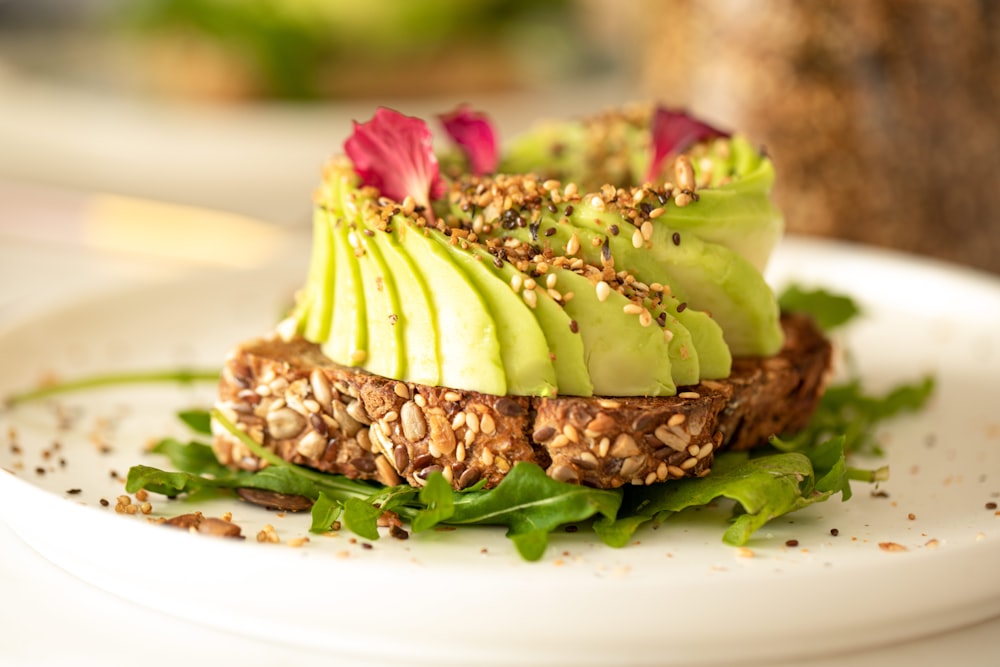 une assiette blanche garnie d’un sandwich recouvert d’avocat