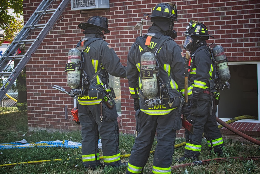 a group of firefighters standing next to a fire truck