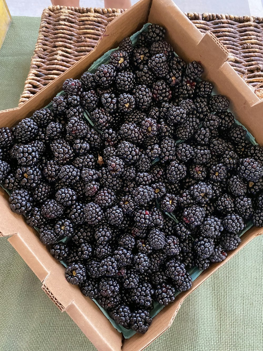 a box filled with blackberries sitting on top of a table
