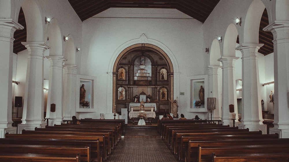 the inside of a church with pews and stained glass windows