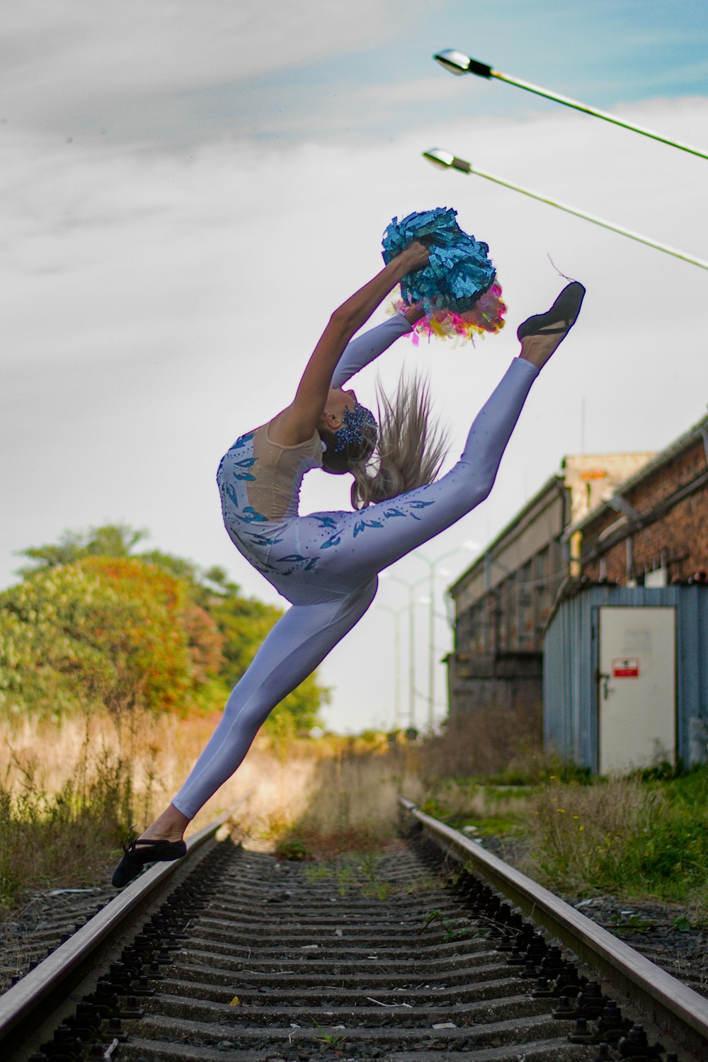 a woman doing a handstand on a train track