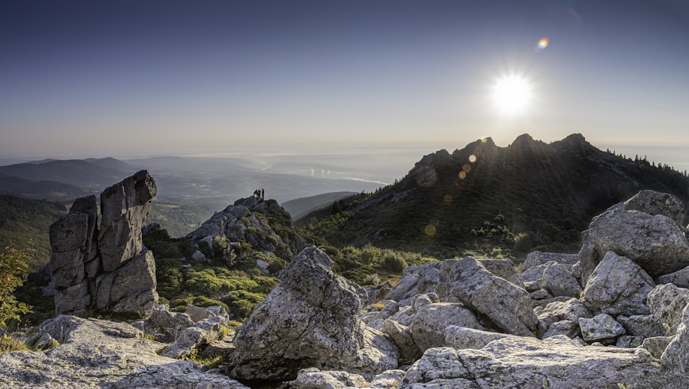 the sun is shining over the mountains and rocks