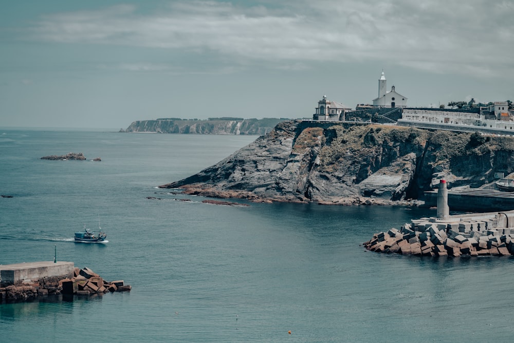 a boat is in the water near a lighthouse