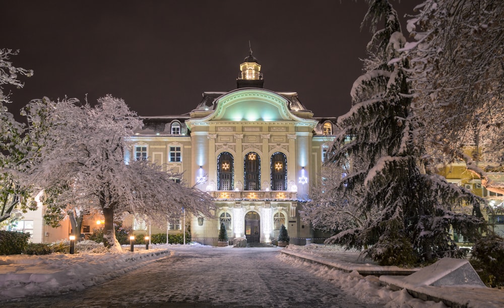 a large building surrounded by snow covered trees
