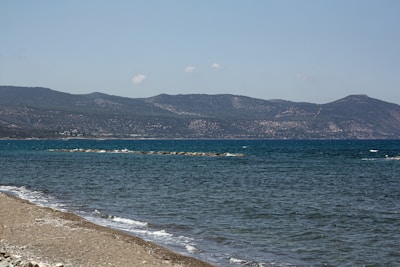 Empty beachfront lot with clear blue skies and gentle waves.