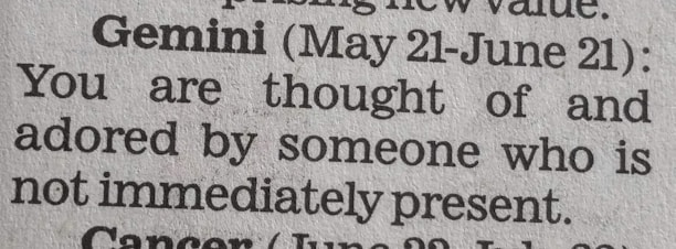 A close-up of a newspaper horoscope section, specifically the entry for Gemini from May 21 to June 21. It predicts that someone who is not present thinks of and adores the reader.