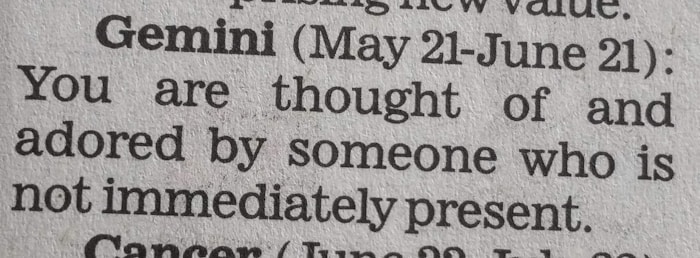 A close-up of a newspaper horoscope section, specifically the entry for Gemini from May 21 to June 21. It predicts that someone who is not present thinks of and adores the reader.