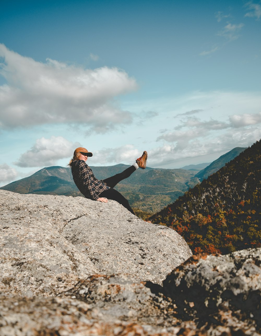 a person sitting on top of a large rock