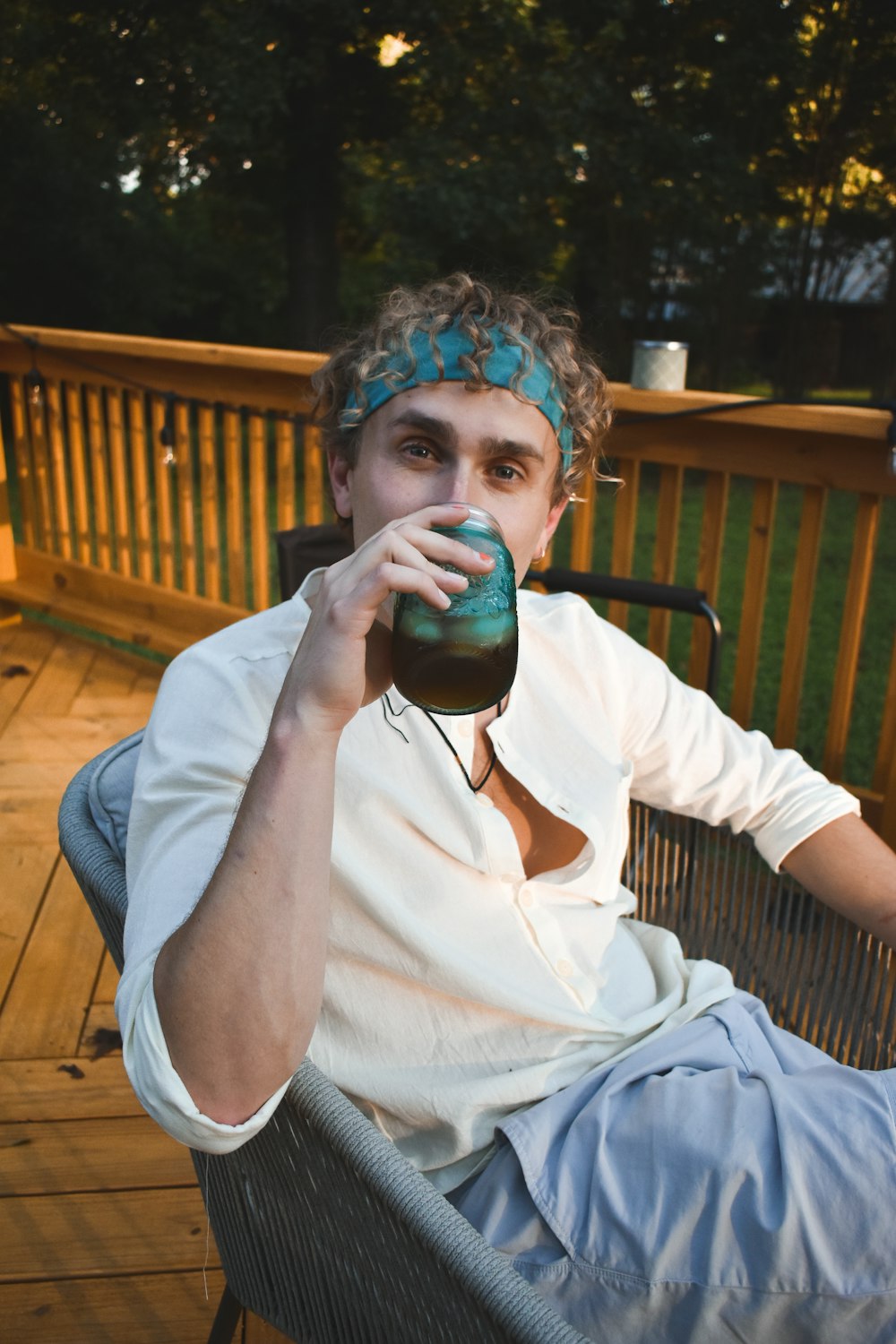 a man sitting in a chair drinking from a cup