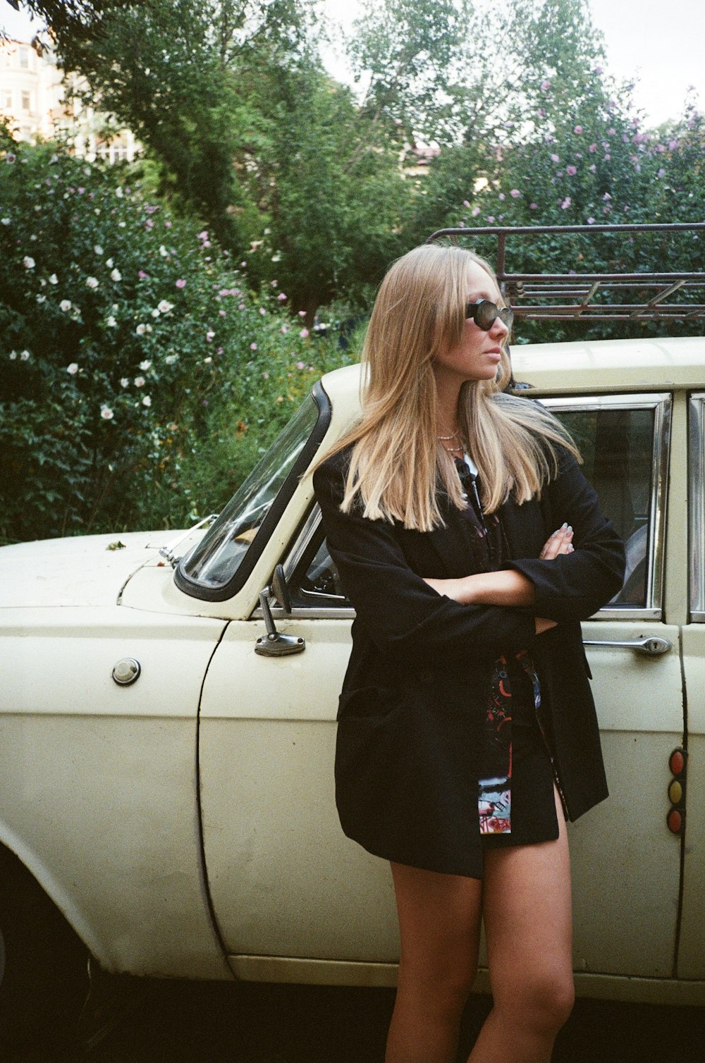 a woman standing in front of a white car