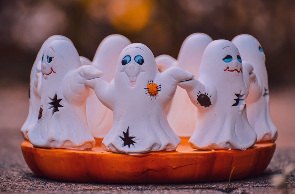 um grupo de figuras fantasmas sentadas em cima de uma bandeja de madeira