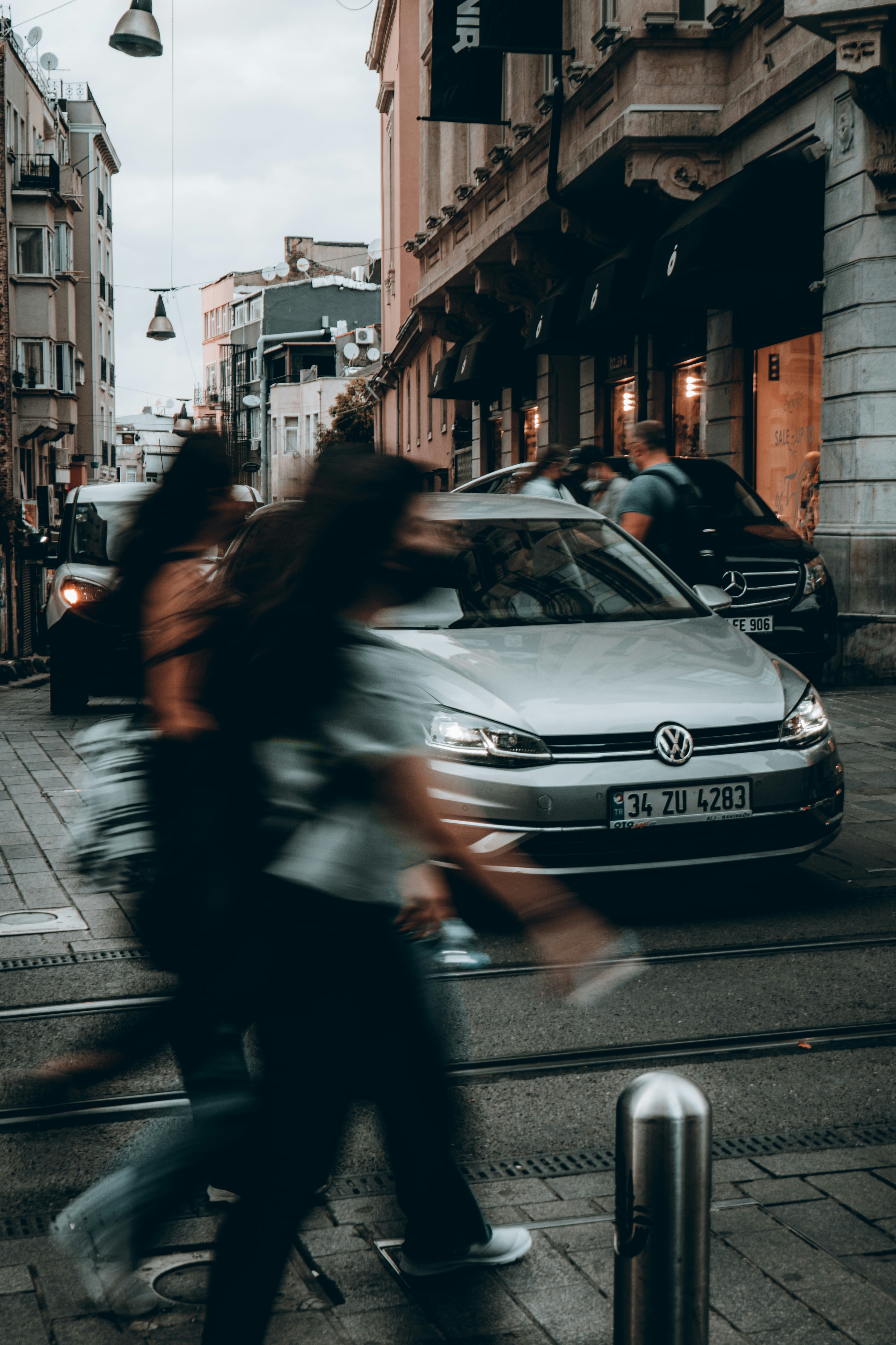 車の隣の通りを歩いている人々のグループ