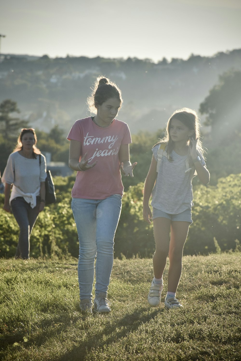 Un par de chicas caminando por un exuberante campo verde